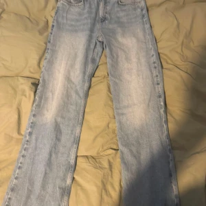 Ljusblå wide jeans från Zara - Säljer ett par ljusblå jeans från Zara i modell med raka och vida ben. Klassisk femficksdesign och hög midja. Jeansen är i bomull och har en snygg tvättad look som passar perfekt till sneakers eller boots. Aldrig använda 