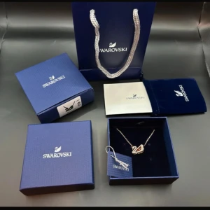  svanhalsband från Swarovski - Elegant halsband från Swarovski med ett gnistrande svanhänge i guldfärg och stenar. Kommer i originalförpackning med certifikat och presentpåse. Perfekt accessoar för att lyfta din stil.