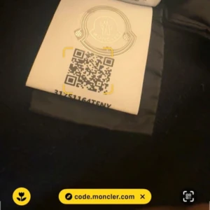 Svart pufferjacka från Moncler - Snygg svart pufferjacka från Moncler med quiltad framsida och två fickor. Jackan har dragkedja framtill och Moncler-logga på ärmen. Ärmar och rygg är i ett annat material än framsidan vilket ger en cool kontrast.