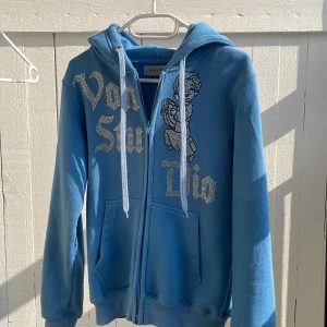 Blå hoodie med dragkedja och tryck från Von studio - Säljer en blå dragkedje tröja från von studio. Inte använd någon gång pågrund av att jag beställde fel storlek och inte kunde skicka tillbaka den. Säljes pågrund av det.