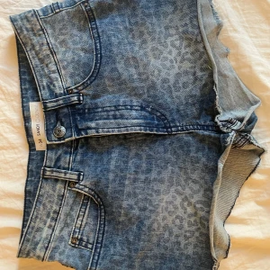 Blå jeansshorts med leopardmönster -  blå jeansshorts från Sandy Denim med leopardmönster. perfekta till sommaren. jeansshortsen är lågmidjade. 