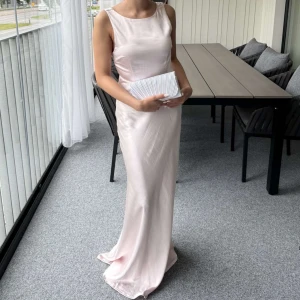 Ljusrosa långklänning i satin - Elegant ljusrosa långklänning i glansigt satinmaterial med öppen rygg och breda axelband. Endast använd vid ett tillfälle och är som ny! Klänningen är uppsydd och passar perfekt för mig som är 165 passar även om man är längre då den är nåra centimeter för lång. Perfekt klänning för bal eller till ett bröllop. Kan tänka mig gå ner med pris vid snabb affär💕inga defekter. orginalpris: 1839kr