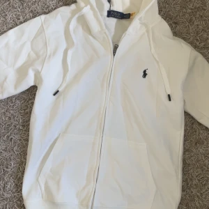 Ralph lauren polo zip hoodie - En helt ny oanvänd vit ralph lauren kofta. Står som M men den passar dig med storlek S. Koftan är som sagt oanvänd alla taggar är kvar och den är inte ens tvättad än!