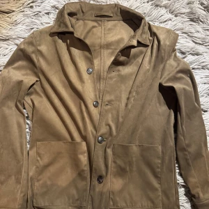 Mocka overshirt - Säljer en väldigt sällsynt overshirt från mango. Köpt i Barcelona på en semester. Extra knappar kommer med i innerfickan. 9/10 skick. Använd fåtal gånger. Storleken är S men passar även M. Perfekt nu till varmare väder. Priset är ej hugget i sten. Bara att höra av sig vid minsta fundering!