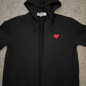 Svart CDG hoodie - Svart CDG kofta med röd logga. Storlek M, väldigt bra skick. Passar dem som har M och L. Pris : 699kr