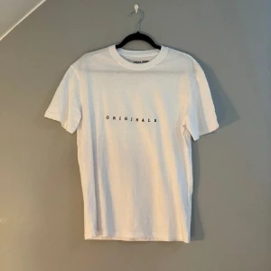Jack & Jones Tshirt - Vit t-shirt från Jack & Jones med svart text 'ORIGINALS' på bröstet. 