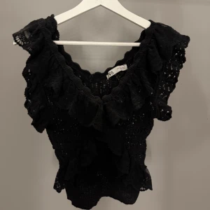 Svart blus med volang och spets från Zara - Säljer en svart blus från Zara med v-ringning, volangdetaljer och spets. fint skick storlek S💕