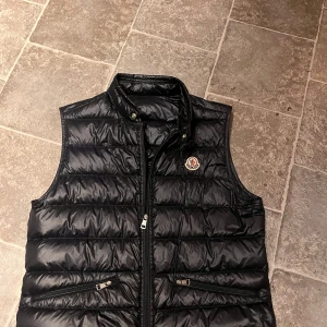Svart dunväst från Moncler - Säljer en Gui väst från Moncler i Navyblå. Inga defekter eller fel på västen. Storlek 3. Hör av dig vid frågor. 