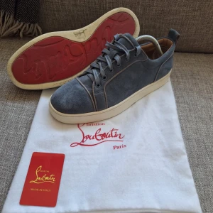  Christian Louboutin - Säljer ett par ljusblå sneakers från Christian Louboutin i mocka med klassisk röd sula. Perfekta för dig som gillar stilrena och exklusiva sneakers. Man får med bag och Louboutin kortet som man ser i första bilden. Priset kan diskuteras.