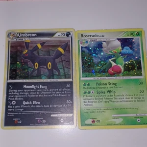 Pokémonkort: Umbreon & Roserade - Två Pokémonkort säljes: Umbreon (svart, holografisk, mörk typ) och Roserade (grön, holografisk, gräs typ). Båda korten har HP 90 och är från olika expansioner. Perfekt för samlare eller Pokémonfans!