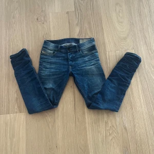 Blå jeansbyxor i slim fit - Snygga blå jeans med lätt slitning och klassisk femficksdesign. Byxorna har en smal passform och normal midja. Perfekta till vardags för en stilren look.