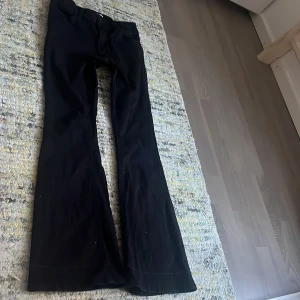 Svarta bootcut byxor från Lindex - Svarta byxor från Lindex med bootcut-passform. Klassisk femficksmodell med normal/låg midja och utsvängda ben. Små märken på byxorna pga att jag vikt upp dem då dem var för långa! Säljer pga av att de är för små! 