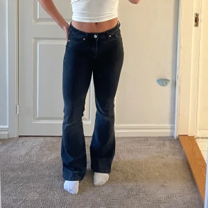 Svarta bootcut jeans - Snygga svarta jeans med bootcut passform . Jeansen är mid/low waist. Slitna nertill.