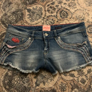 Lågmidjade Jeansshorts från Superdry  - Lågmidjade jeans shorts från Superdry. Väldigt bra skick. Bilden med midjemåttet var inte så synlig men måttet på midjan är 40cm💘