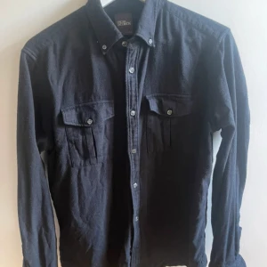 Oscar Jacobsson overshirt - Säljer min overshirt i storlek L men sitter som en medium. Skicket är väldigt bra och är i marinblå färg.