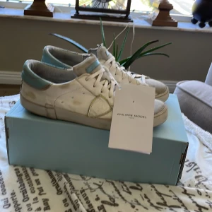 Philippe Model skor - Snygga vita skor från Philippe Model med ljusblå detaljer och har även text på sulan. Riktigt feta i 7/10 skick. Nypris runt 3000. Storlek 41 passar 42. Priset är ej hugget i sten, kom med förslag!