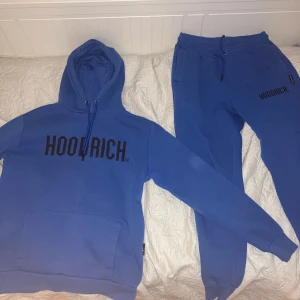 Blå Hoodrich set för endast 400kr - Säljer en blå hoodie från Hoodrich med svart tryck på bröstet. Tröjan har huva med dragsko och en stor magficka. Perfekt för en avslappnad stil och passar bra till vardags.