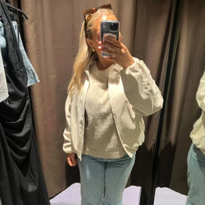 Beige bomberjacka - Säljer en stilren beige bomberjacka med dragkedja framtill. Jackan har en klassisk bombermodell med normal passform och långa ärmar. Perfekt att slänga på sig över en t-shirt eller stickad tröja. Passar till det mesta och ger en clean look.