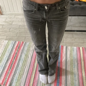 Grå jeansbyxor med raka ben - Säljer ett par grå jeansbyxor med normal passform och raka ben. Klassisk femficksmodell med knapp och dragkedja framtill. Snygga detaljer på bakfickorna. Perfekta till många olika stilar.