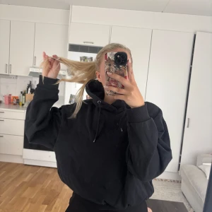 Svart hoodie med luva - Säljer en svart hoodie med luva och dragsko. Tröjan har en oversized passform och är tillverkad i mjukt material, perfekt för en avslappnad stil. Klassisk design utan tryck eller mönster.