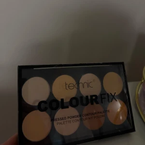 Colour Fix Contour Palette från Technic - En contourpalett med åtta pressade puder i olika beige och bruna nyanser. Perfekt för att skulptera och highlighta ansiktet. Kommer i en svart plastförpackning med genomskinligt lock.