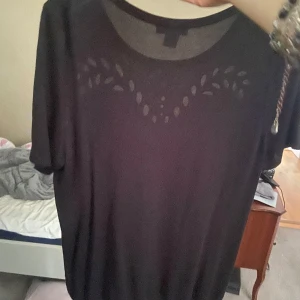 Svart stickat T-shirt - Svart kortärmad tröja från H&M, med snygga detaljer! Passar xs-m skulle jag säga. Använd max 1 gång!