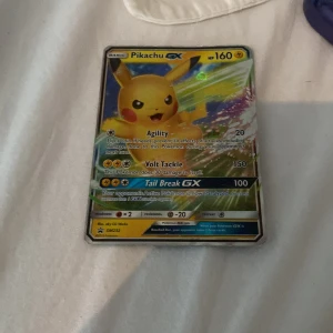 Pikachu GX - Det här är ett samlarkort med Pikachu GX från Pokémon-serien. Kortet har färgstark design och visar Pikachu i en kraftfull pose. Perfekt för dig som gillar Pokémon och vill utöka din samling med ett coolt och populärt kort. 