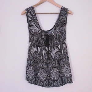 Lucky's Paris topp strl M-L - Topp från Lucky's Paris i vackert mönster i vitt, grått och mörklila, djup urringning både fram och bak. Det står ingen storlek men den är väldigt elastisk runt armar och runt bysten, så jag estimerar att den nog passar flera olika storlekar ca M till L. Men kan mäta och ta fler bilder vid intresse!