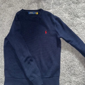 Mörkblå stickad tröja från Polo Ralph Lauren - Mörkblå stickad tröja från Polo Ralph Lauren, mycket bra skick. Tröjan är liten i storlek och sitter mer som en xs