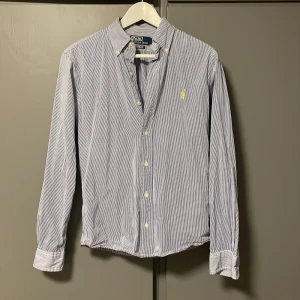 Blårandig skjorta från Polo Ralph Lauren - Säljer en blårandig skjorta från Polo Ralph Lauren i storlek Small. Skick: 10/10, använd men är som ny! Nypris: Ca 2000kr. Skjortan passar dig som är mellan 170-180. Kontakta för fler frågor!