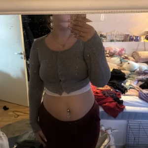 Grå croppad kofta från FB Sister - Säljer en grå croppad kofta från FB Sister i storlek M. Koftan har långa ärmar och knappar framtill. Perfekt att slänga över ett linne eller t-shirt för en chill look. Supermjuk och enkel att matcha med det mesta!