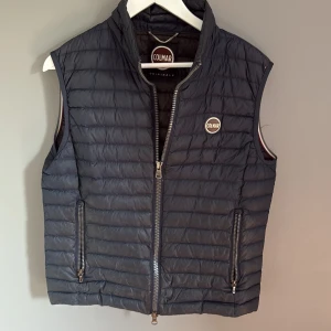 Mörklblå Colmar väst - Snygg svart dunväst från Colmar med quiltad design och dragkedja framtill. Västen har två fickor med dragkedja och en hög krage. Perfekt för lager-på-lager och enkel att matcha med olika outfits.