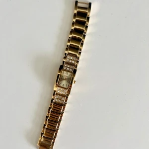 Guldfärgad klocka med glittriga detaljer - Klocka, måste bytas batteri 