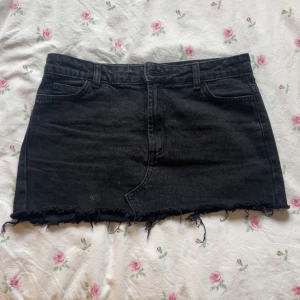 Svart jeanskjol med fransig kant - Säljer en svart jeanskjol med rå, fransig nederkant och klassiska fickor både fram och bak. Perfekt inför sommaren både till vardags och på fest. Säljer då den tyvärr är för liten för mig❤️