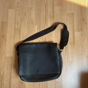 Svart Pier One Portfölj - Säljer denna då den inte längre används.  Finns skavanker som visas på bild 3 & 6.  Pris går att diskuteras.  Fler bilder kan fixas vid förfrågan.