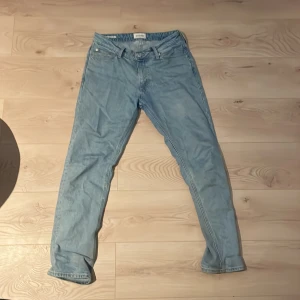Ljusblå jeans från Jack & Jones - Säljer ett par ljusblå jeans från Jack & Jones med en klassisk femficksdesign. De har en normal passform och är tillverkade i denim. Perfekta för en avslappnad stil.