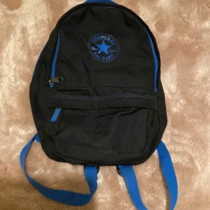 Svart ryggsäck från Converse - Snygg svart ryggsäck från Converse med blå detaljer och dragkedja. Kan vara små fläckar på. Längd: ca 37cm. Bredd: ca 21cm. Pris kan diskuteras! 💕