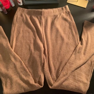 Beige ribbade byxor från Shein - Säljer ett par bekväma beige ribbade byxor från Shein. Byxorna har en elastisk midja och är perfekta för en avslappnad stil. De är tillverkade i ett mjukt material som ger en skön känsla hela dagen.