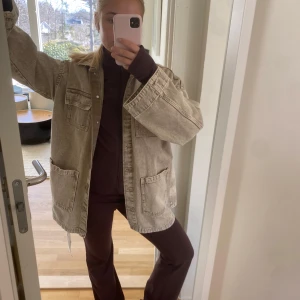 Beige jeansjacka med bälte - Säljer en beige jeansjacka med knappar och knytbälte i midjan från H&M. Jackan har stora fickor framtill och en avslappnad passform. Perfekt för en cool och avslappnad stil. Den är knappt använd och i storlek M (storleken står ej)🥰❤️
