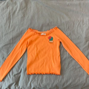 Långärmad tröja - Säljer en cool orange långärmad tröja med en söt kaktusdetalj på bröstet. 🌵 Tröjan har volangdetaljer vid halsringningen, nederkanten och i slutet på ärmarna som ger en extra touch. Den är inte ny men den är aldrig använd. Skriv privat för frågor, o läs helst min bio innan du köper✨🫶🏻