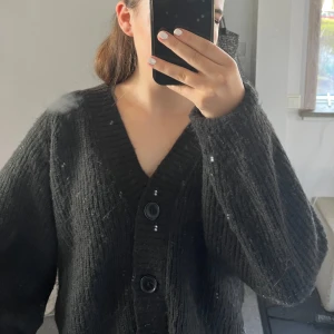 Svart stickad kofta från Gina tricot - Säljer en svart stickad kofta från Gina men köpt på Sellpy med knappar framtill. Koftan har en v-ringad design och långa ärmar, perfekt för kyligare dagar. Den är både stilren och bekväm, ett måste i garderoben! 🖤priset kan diskuteras! Säljer pga att jag beställde 2 st i orlika storlekar❤️ 