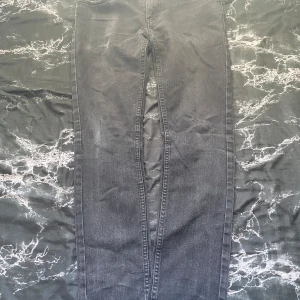 Svarta jeans från Levi Strauss & Co. - Snygga svarta jeans från Levi Strauss & Co. med klassisk design och fem fickor. Jeansen har en normal passform och är tillverkade i slitstarkt denim. Perfekta för en stilren look.