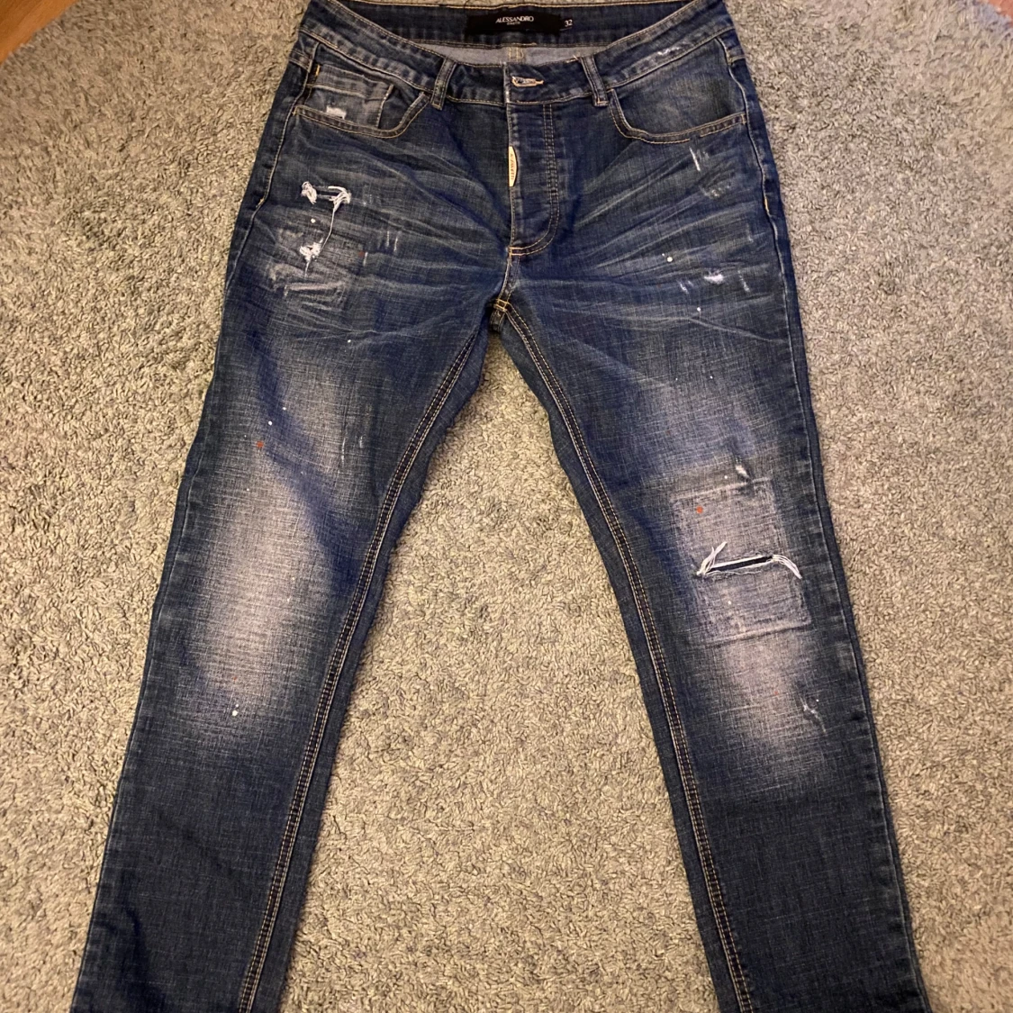 Blå jeans med slitningar från B.P.R.D
