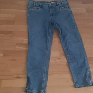 Blå jeans med dragkedja - Snygga blå jeans med dragkedja vid bensluten. De har en klassisk femficksdesign och en bekväm passform. Perfekta för en avslappnad stil.