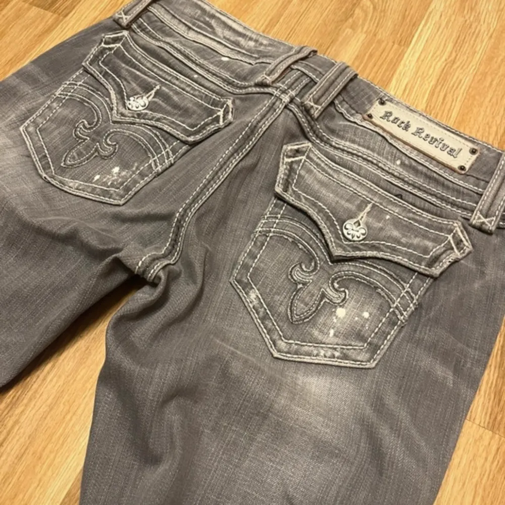 Snygga grå jeans från Rock Revival med slitna detaljer och broderade bakfickor. . Farkut & Housut.