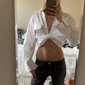 Vit croppad skjorta - Snygg vit croppad skjorta med långa ärmar och knyte framtill. Helt ny aldrig använd, inga defekter. 