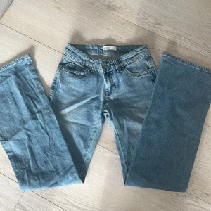 Blå jeans från Gina Tricot - Säljer ett par klassiska blå jeans från Gina Tricot. De har en rak passform och är tillverkade i denim. Perfekta för en avslappnad stil. Märkeslappen på baksidan ger en snygg detalj.🩷🩷