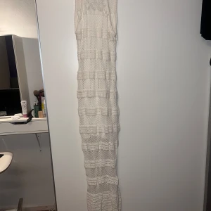 Vit stickad långklänning från Guess - Säljer en elegant vit stickad långklänning från Guess. Klänningen har ett vackert stickat mönster. Lång cremefärgad figurnära klänning från lyxmärket Guess. Perfekt som en lyxig strandklänning men även som en fin långklänning. Den har tyg undertill så den inte är genomskinlig. Köpt i Guess butiken i London för ett år sen men aldrig använd då den inte passade min kropp. Inga defekter. Har bildbevis på att den är äkta Guess och QR koden på klädlapparna leder direkt till hemsidan. 💕