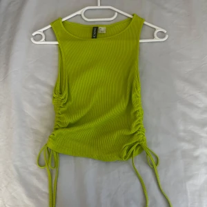 Grön ribbad linnetopp från Shein - Snygg grön ribbad linnetopp med  knytbara detaljer på sidorna. Perfekt för en somrig look. Toppen är ärmlös och har en croppad passform.