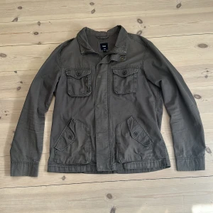 GAP vårjacka - Stilren vårjacka från GAP. Snygg grå/grön färg. Har lite små tecken på användning men inga större defekter. Pris går att diskutera